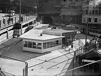 Station Slussen med tunnelbanetåg och biljetthall. Till vänster Katarinavägen och i fonden tunneln in i Katarinaberget.