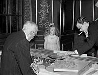 Kronprins Gustaf Adolf spelar spel medan Kung Gustaf V och Prinsessan Birgitta tittar på.