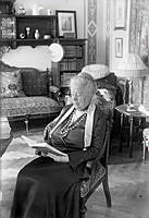 Författare Selma Lagerlöf sitter och läser i biblioteket på Mårbacka vid sin 75-årsdag.