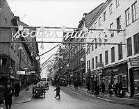 Götgatan juldekorerad. Till vänster mjölkvagn med mjölkkannor.