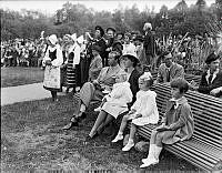 Prins Gustaf Adolf och prinsessan Sibylla med två av sina döttrar, prinsessorna Margaretha och Birgitta, sittande på en bänk på Barnens dag på Skansen.