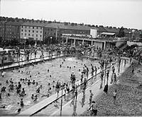 Badande vid nyöppnade Vanadisbadet, Stockholms första parkbad. Bassänger med eluppvärmt vatten och solterrass med utsikt över Sveavägen invigdes under en oväntad värmebölja i maj 1938.