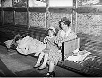 En kvinna med två barn äter dricker och sover på en bänk på Centralstationen.