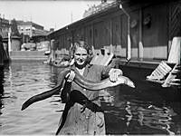 Kvinna håller upp en ål vid fiskhallen vid Munkbron i Gamla Stan.