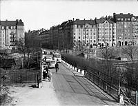 Trafikanter på Tomtebodabron och Karlbergsvägen öster ut mot Vasastan med kvarteret Skålen till vänster och kvarteret Kadetten till höger. Vägen förband Stockholm och Solna.