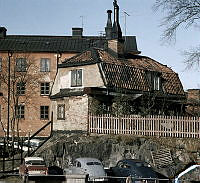 Putsat envånings trähus och i bakgrunden ett flerfamiljshus, Gamla Lundagatan 2  (f.d. Ludvigsbergsgatan 15) , kvarteret Somens kvarn.