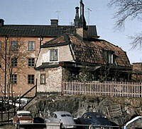 Putsat envånings trähus och i bakgrunden ett flerfamiljshus, Gamla Lundagatan 2  (f.d. Ludvigsbergsgatan 15) , kvarteret Somens kvarn.