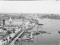 Östra Slussgatan, Karl Johans Torg, Slussplan och Skeppsbron  från Katarinahissen. Fiskarhamnen i förgrunden och Räntmästarhuset till vänster. Till höger Skeppsholmen.