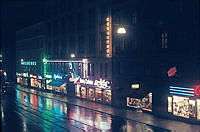Sankt Eriksgatan 46. Butikernas neonskyltar lyser i mörkret.