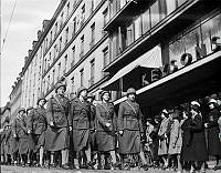 Luftskyddsparad med kvinnor i uniform och hjälmar som marscherar på Sturegatan.