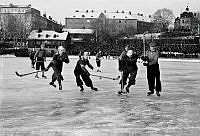 Hammarby idrottsplats. Kanalplan. Bandymatch Hammarby-Västerås. Hammarbyförsvaret med fr.v. Gunnar Landelius, Åke Andersson, Herbert Östlund i strid med Västerås spelare Serrander med höjd klubba.