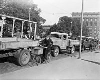 Trafikträngsel på Norrbro med öppen spårvagn, cyklister, bilar och lastbilar. I fonden Slottet.