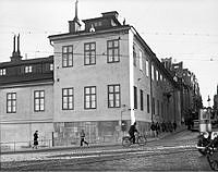 Hörnet Hornsgatan och Götgatan med Gamla södra stadshuset (Stadsmuseet) vid Södermalmstorg och kvarteret Stadsgården har fiffats upp. Trådbusslinor hänger över vägen.