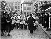 Musikkår på julmarknaden vid Stortorget i Gamla Stan. I bakgrunden kvarteren Aesculapius och Echo.