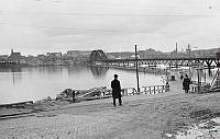 Vy västerut från Lidingö mot nya Lidingöbron under byggnad. I fonden Hjorthagen och Värtagasverket.