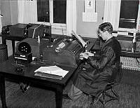 Tidningarnas Telegrambyrå AB (TT). Sändarrumet med apparatur där en man skriver på en teleprinter.