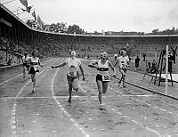 Under Internationella dövstumspelen på Stadion i Stockholm korsar kvinnor mållinjen i löpning.