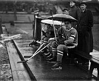 
Ishockeyspelare sitter i avbytarbåset med paraplyer på Stadion under matchen mellan Hammarby - Göta.