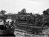 Hästar och beredskapssoldater transporteras på en flotte under höstmanöver i samband med andra världskriget.