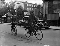 Två män med en stege med flyttlast mellan sina cyklarna under en oktoberflytt hösten1939.