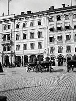 Några hästfordon står på Gustav Adolfs Torg utanför Hotell Rydberg vid Gustav Adolfs Torg 16. Kvarteret revs 1913 för Skandinaviska Bankens palats. Nuvarande Gustav Adolfs Torg 22-24.