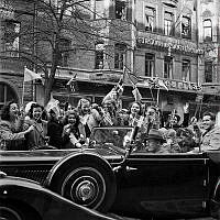 Fredsdagen den 7:e maj 1945. 

Glada människor i bilar och på gatan viftar med flaggor på Birger Jarlsgatan.