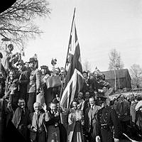 Fredsdagen den 7:e maj 1945 i Stockholm. 
Glada och flaggviftande människor firar freden.