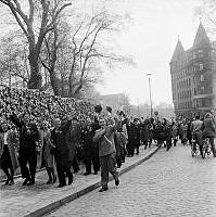 Fredsdagen den 7:e maj 1945. 
Glada flaggviftande folkmassor längs Strandvägens östra del. 
Till vänster vedtravar längs gatan.