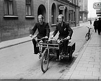 Två herrar på en Tandempaket cykel.