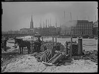 Vedupplag på Söder Mälarstrand. I bakgrunden Järnvägsbron, Riddarholmen och Mälartorget.