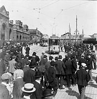 Strejkande på Roslagsgatan (nuvarande Birger Jarlsgatan) under storstrejken 1909. Spårvagnshallarna och spårvagnar.