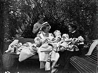 Tre kvinnor varav en Sophiasyster med tio spädbarn utomhus.