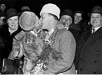 En kvinna kysser en man som just kommit hem efter att som frivillig deltagit på Finlands sida i Vinterkriget mot Sovjetunionen.