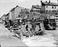 Götgatan norrut med vält hästdragen mjölkvagn från Mjölkcentralen. Längre bort på gatan syns hästen och till höger kvarteret Monumentet med husen vid Götgatan 89 - Gotlandsgatan 42 på berget.