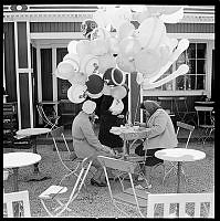 Ballongförsäljerska tar kaffepaus på ett utecafé.