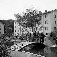 Barn på gångbro över plaskdammen i kvarteret Bronsen, senare kallad Tengdahlsparken. I fonder bostadshus i kvarteret Stålet.