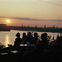 Människor vid cafébord på Fåfängan. Utsikt över Saltsjön och Strömmen mot Gamla Stan. Mot nordväst.