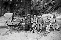 Gruppbild med barnvagn och fyra barn som sitter på en bänk vid en utflykt med Föreningen Engelbrekts baranavärn och husmodersskola.