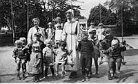 Kungsholmens västra barnkrubba. Barn och barnsköterskor på lekplatsen.