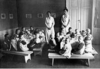 Interiör från Maria församlings västra barnkrubba, Ansgariegatan 5 i Wirwachska malmgården med barn och personal runt matbord.
