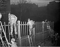 Hemvärnet övar gatustrider i Stockholm. Uniformsklädda män klättrar över staket.