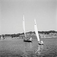 Reportage från Sandhamn under sandhamnsregattan 1941. Den nordiska seglarfesten.
Med en fläkt från sol, sommar och Sandhamn. Två segelbåtar i tävlingen.
