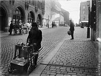 En skärslipare med sin vagn och slipsten på Nybrogatan utanför Östermalms Saluhall.