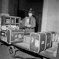 En man lastar resgods på vagnar på Stockholms central julen 1954.