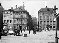 Folkliv vid Skeppsbron. Skeppsbron 20 och 18. Hamburgerbryggeriet distribuerar flaskor med häst och vagn.