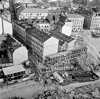 Vy från det första nybyggda höghuset vid Hötorget. Rivning och schaktning inför förlängningen av Sveavägen. Kvarteren Uppvaktaren och Putten står till viss del fortfarande kvar. 
