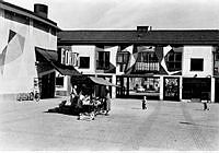 Vy över Årsta torg med biograf Forum till vänster och passagen genom kvarteret Åsjön mot Hjälmarsvägen.