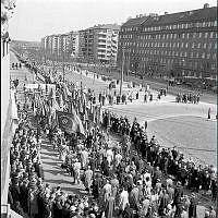 Demonstrationståg på väg österut på Valhallavägen mot Gärdet. Första maj demonstration på gammal och beprövat sätt med musikkår, standar, fanor, paroller och åskådare.