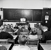 Skol-TV på försök i ett tiotal skolor i Stockholm. Barn i skolbänkar tittar på en TV-apparat.