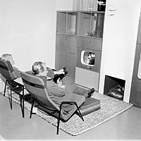 En kvinna och man sitter och tittar på TV, i Varuhuset NK:s TV-rum på möbelavdelningen